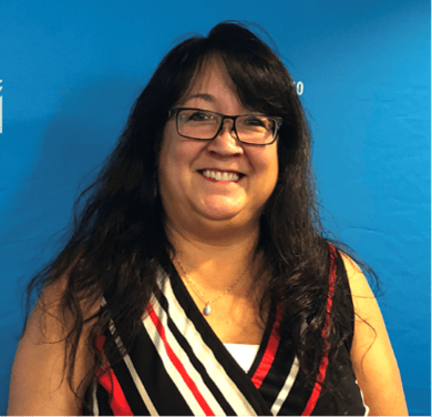 Portrait of Diane Redsky, Chair of the MMIWG2S+ Urban Indigenous Action Group against a blue background.