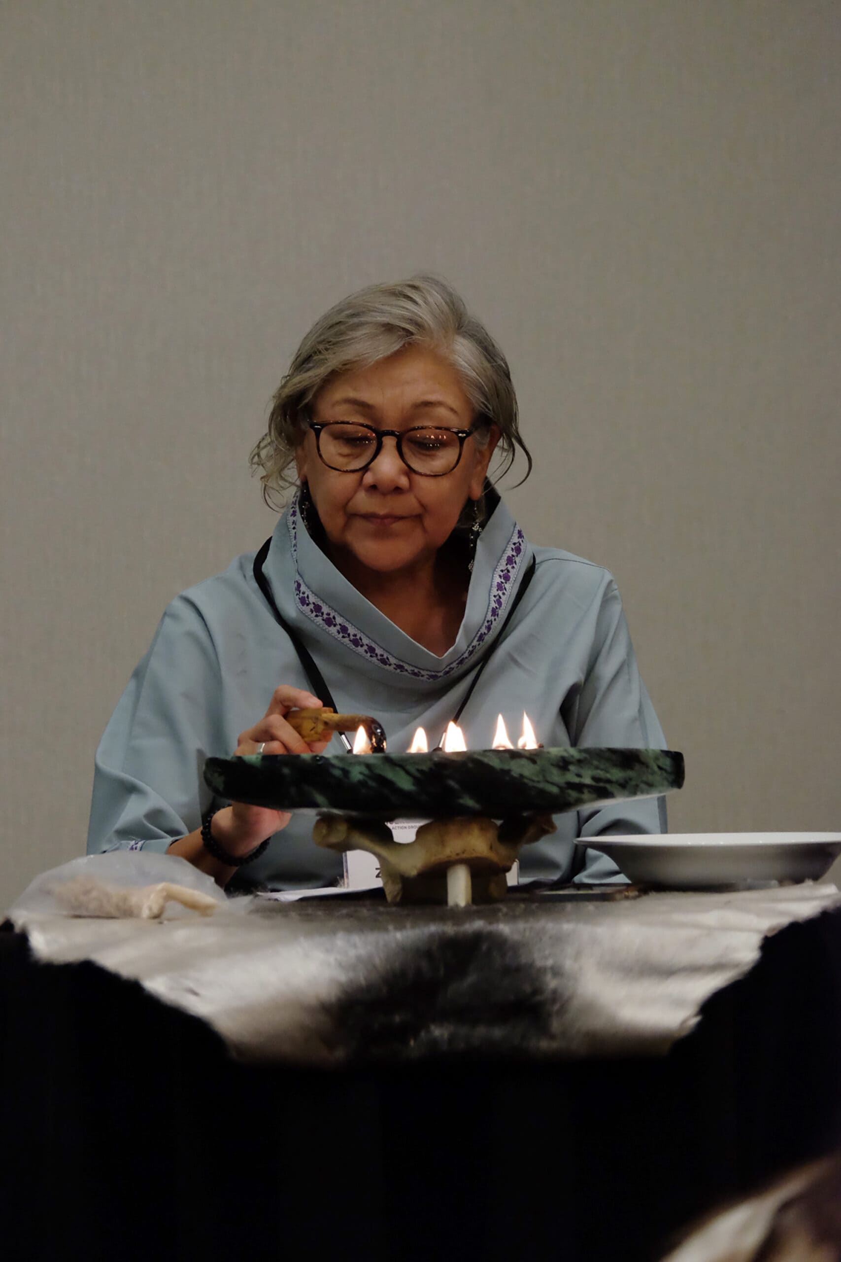 Inuk elder Zippy Nochashak opens the the summit by lighting the Qulliq. 